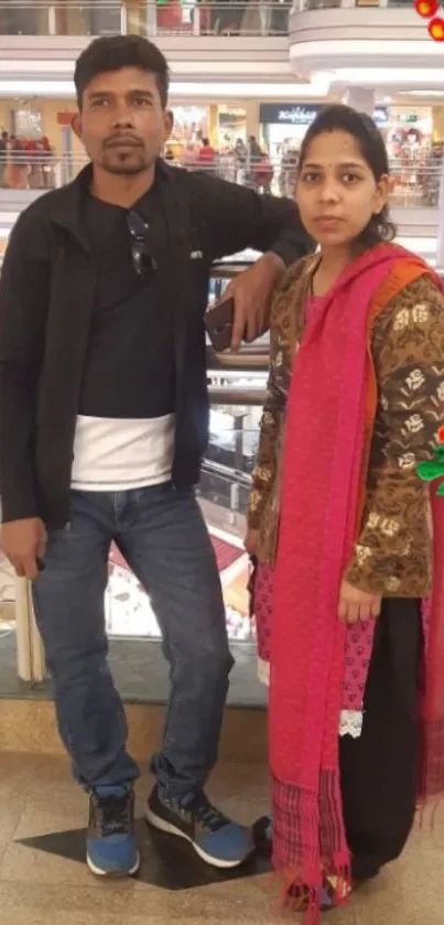 A couple standing in a shopping mall decorated with festive elements.