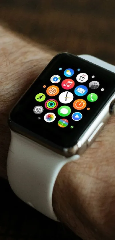 Smartwatch with colorful app icons on wrist against a wooden background.