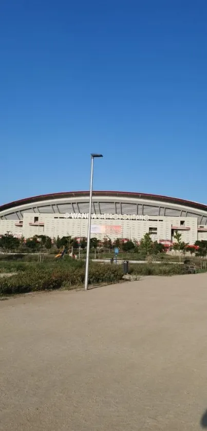 Modern stadium under a vibrant blue sky, perfect for mobile wallpaper.