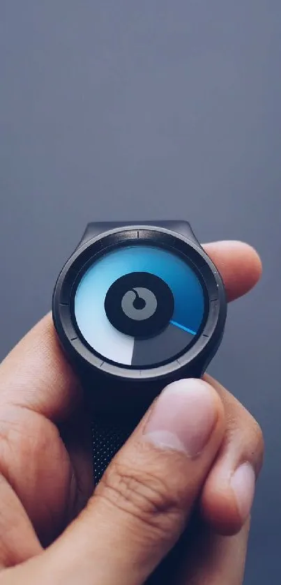 Hand holding modern tech device with blue-gray design.