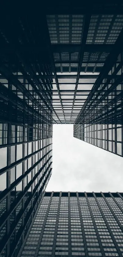 Gray urban skyscrapers forming a symmetrical view looking upwards.