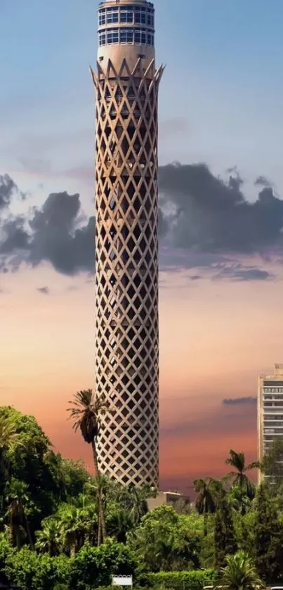 Cairo Tower at sunset with lush greenery and vibrant sky.