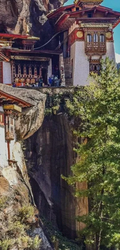 Monastery on cliff with green forest and mountains.