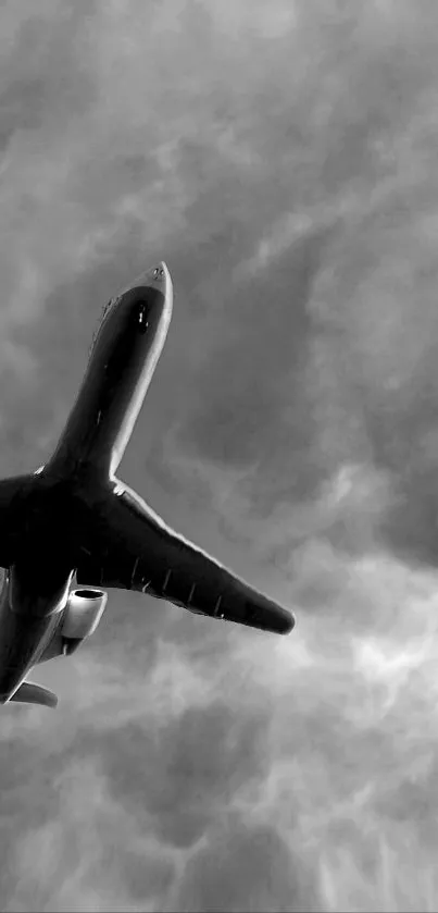 Monochrome airplane silhouette against a textured cloudy sky.