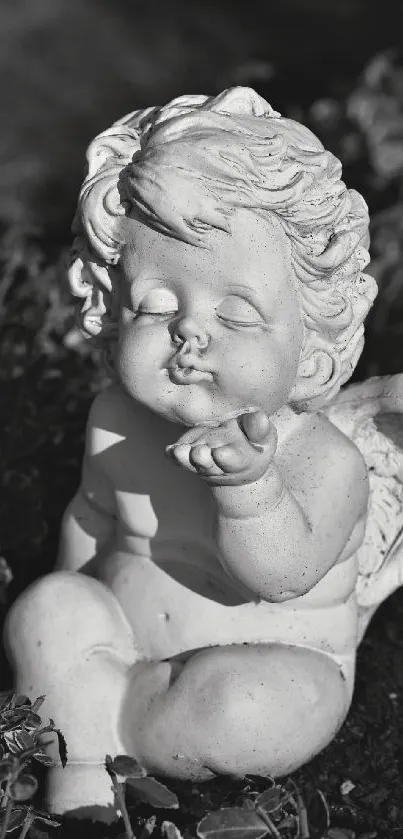 Monochrome angel sculpture amidst foliage.