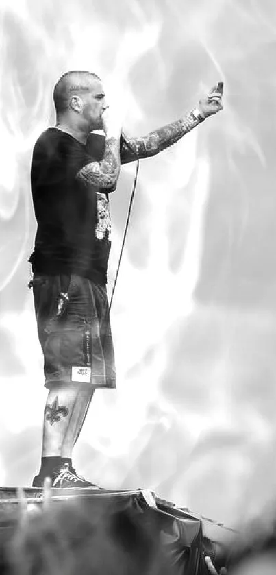 Tattooed musician performing at a concert in grayscale.