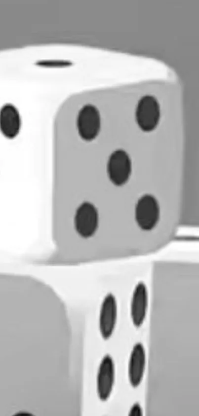 Monochrome dice with black pips stack elegantly on a gray background.