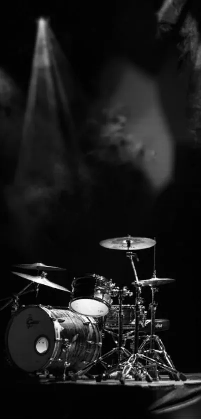 Black and white drum kit on stage with spotlight.