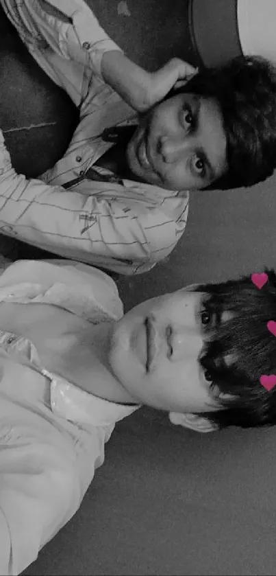 Black and white photo of two friends with heart filter effect.