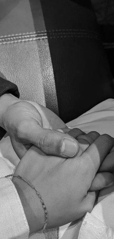 Black and white image of hands holding each other, symbolizing friendship and love.