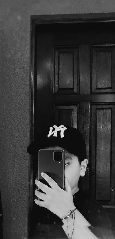 Monochrome mirror selfie with a cap.