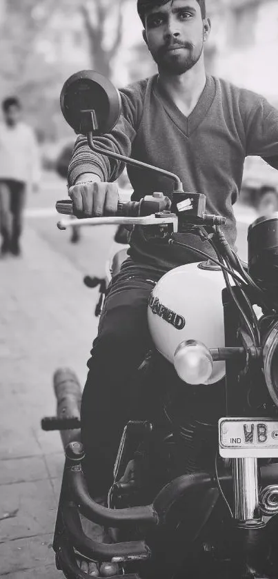 Monochrome image of a man riding a motorcycle on a street.