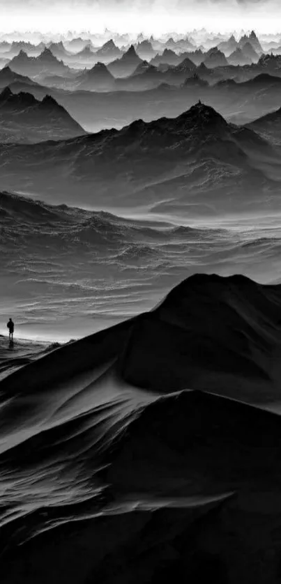 Monochrome mountain landscape with dramatic peaks and a lone hiker.