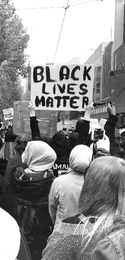 Protesters holding a Black Lives Matter sign in a monochrome street scene.