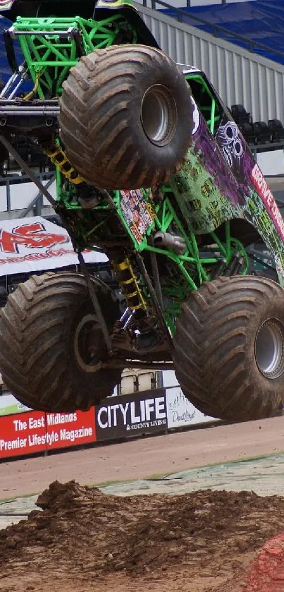 Monster truck soaring through stadium dirt track.