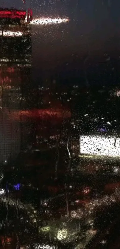 Raindrops on a window overlooking illuminated city at night.