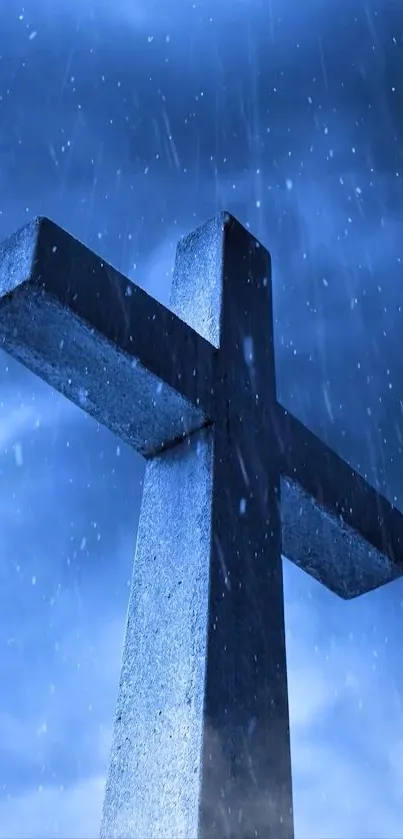 Cross in rain with dramatic blue sky background.