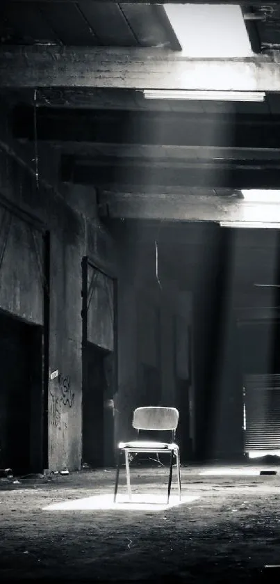 Moody industrial scene with chair illuminated in a dark warehouse.