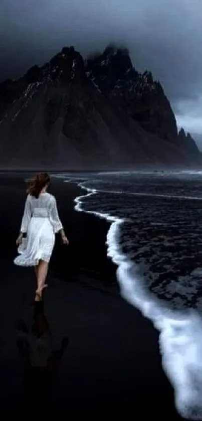 Moody mountain and beach with dark ocean waves at dusk.
