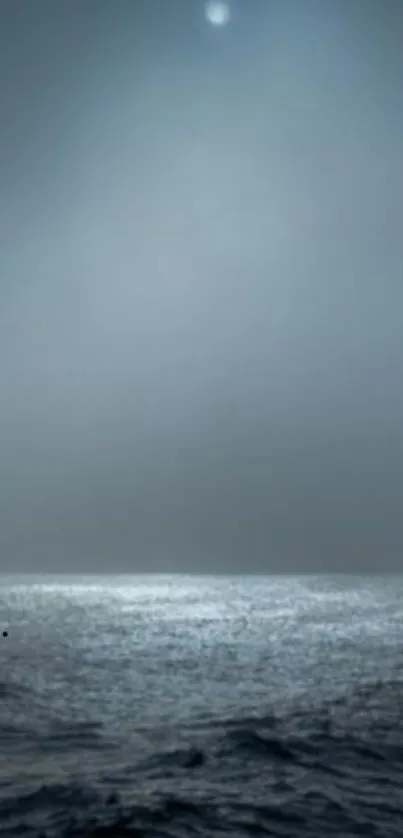 Misty night ocean with moonlit water.