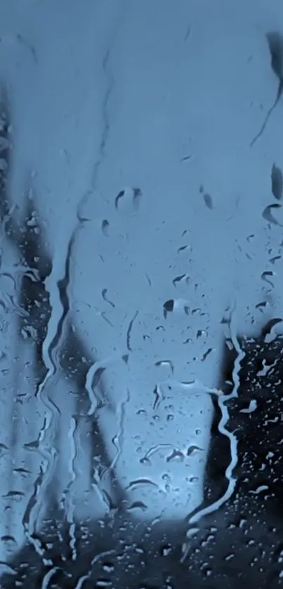 Abstract moody blue rainy window wallpaper with water droplets.