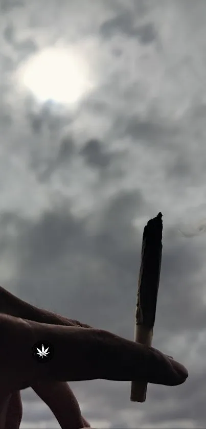 A hand holds a roll against a cloudy sky.