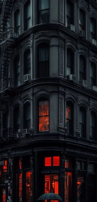 Vintage building with red lit windows at night.