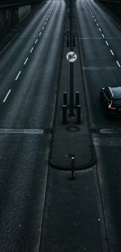 Moody urban road with a single car at night.