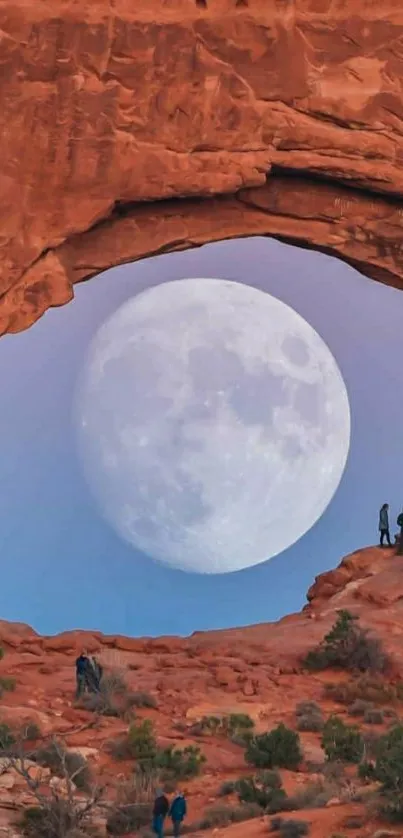 Full moon rising through a red rock arch in a desert landscape.