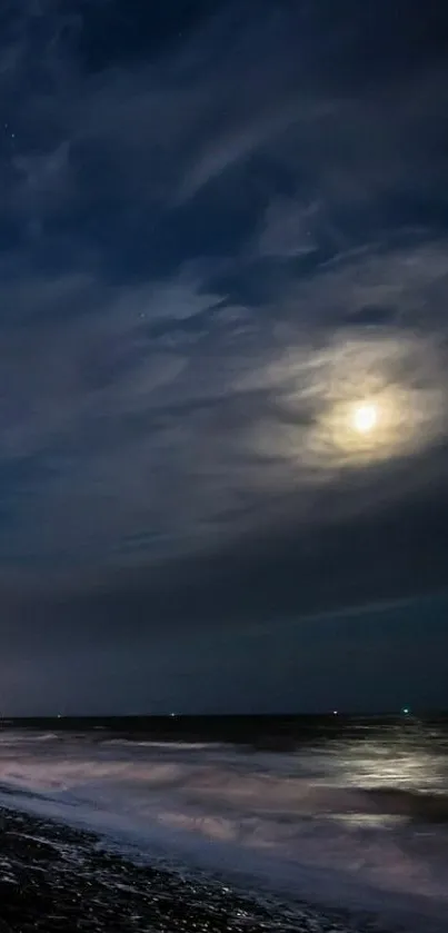 Moonlit beach with gentle waves under a tranquil night sky.