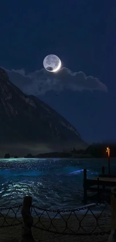 Moonlit night over a calm beach with scenic mountains.