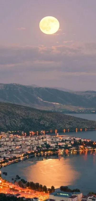 Moonlit coastal cityscape with mountains and shimmering water at night.