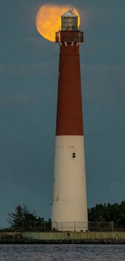 Lighthouse with glowing moon in a serene night view, perfect for mobile wallpaper.