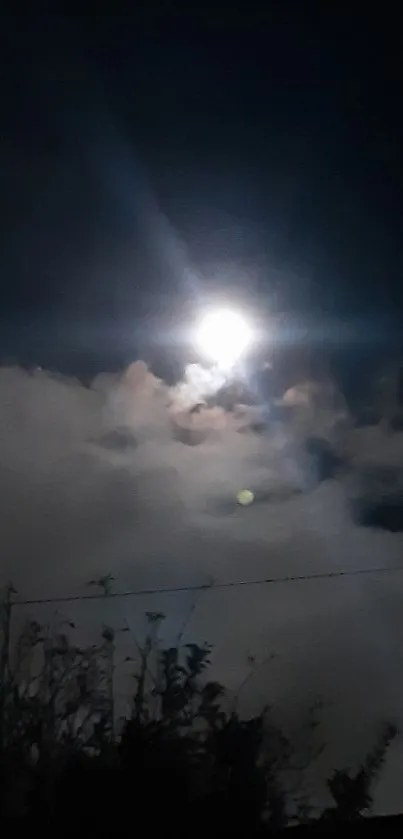 Moonlit sky with clouds in a serene night scene.