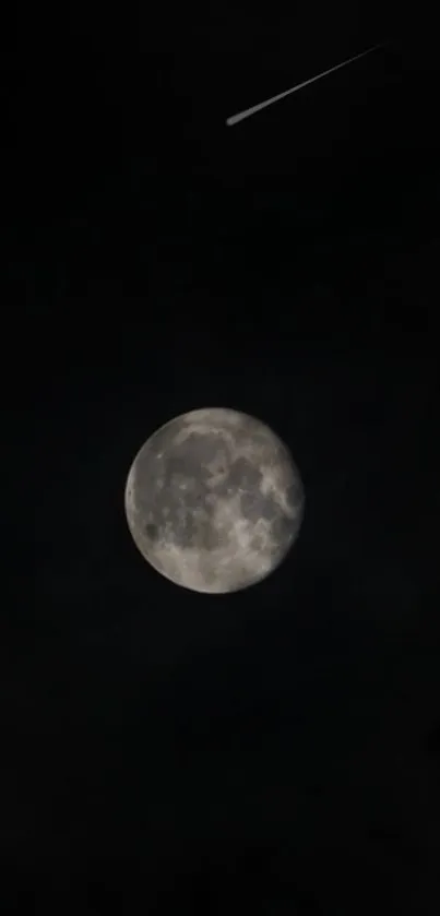 Full moon and shooting star in a dark night sky.