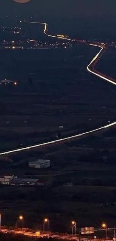 A serene night view of a road winding under a bright, full moon in the night sky.