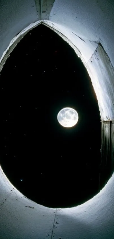 Full moon visible through a unique architectural opening at night.