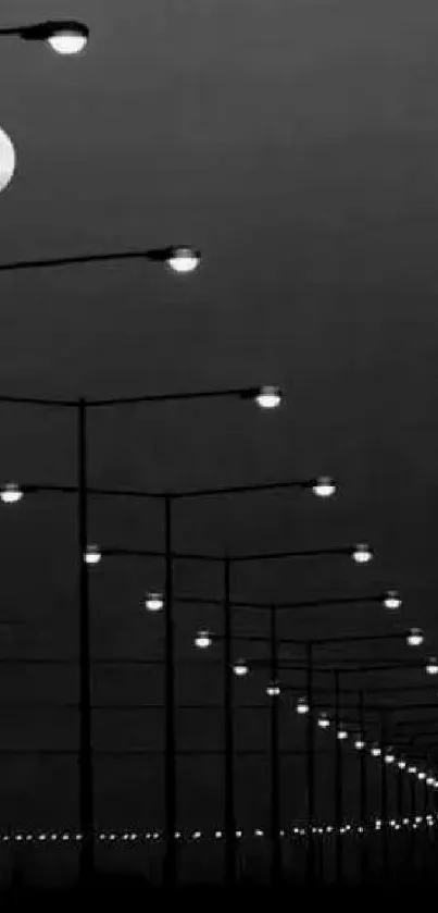 Black and white wallpaper with moonlit street lamps at night.