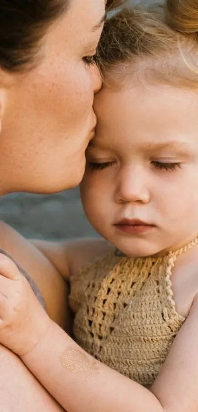 Mother lovingly kisses her child with eyes closed.