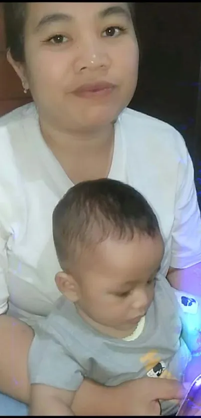 Mother holding child while looking at a phone.