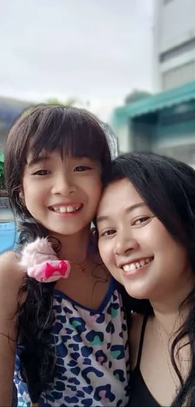 Smiling mother and daughter in vibrant family portrait.