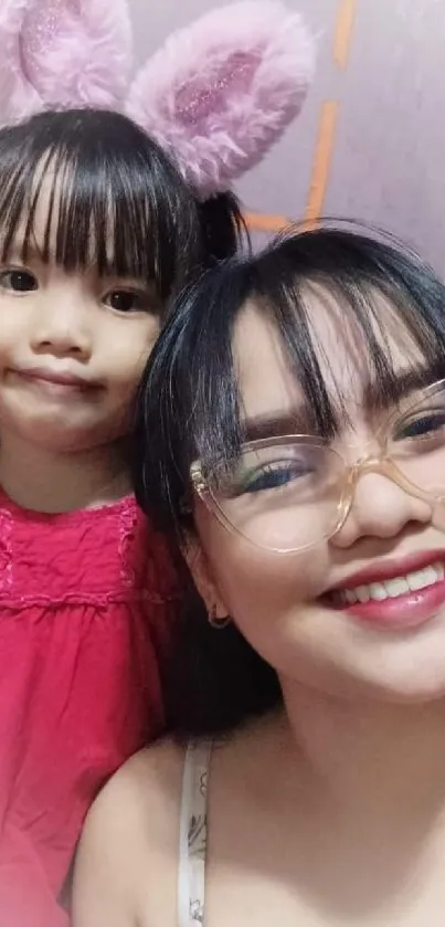 Mother and daughter smiling with bunny ears.