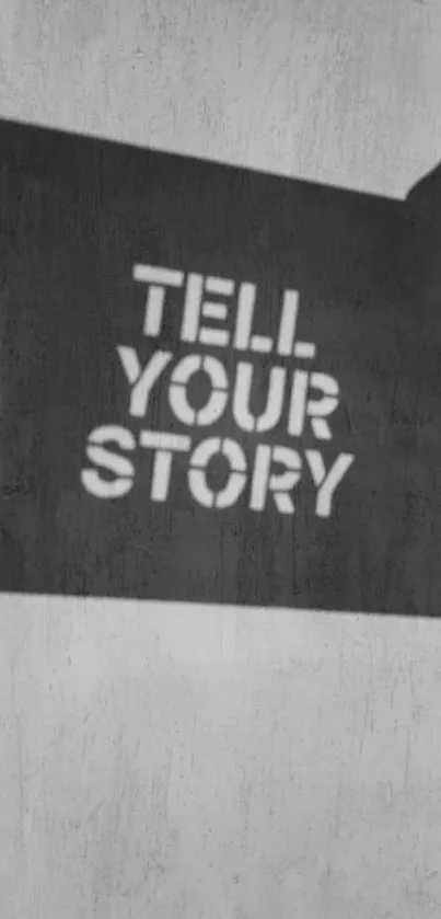 Inspirational wallpaper with 'Tell Your Story' in black stencil on grey background.