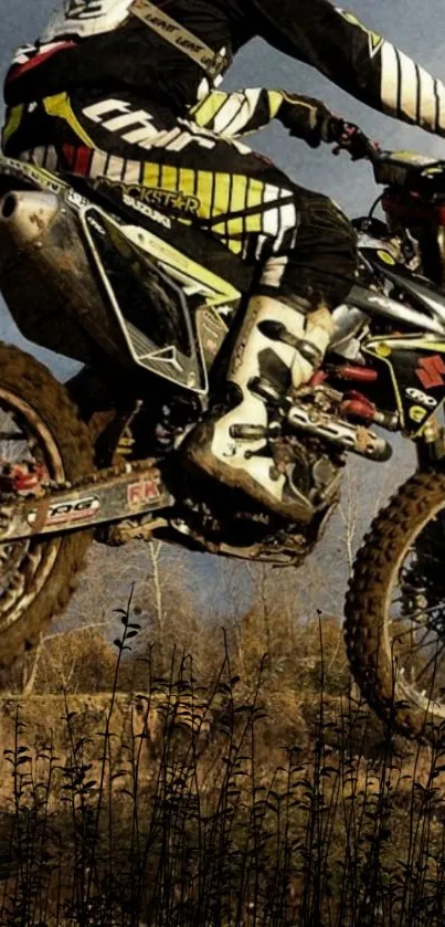 Motocross biker jumping over dirt track in dynamic wallpaper shot.