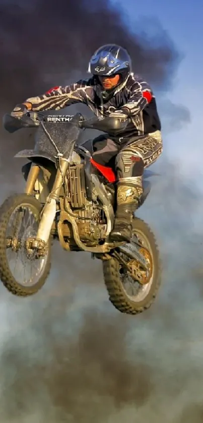 Biker performs a motocross jump against a clear blue sky.