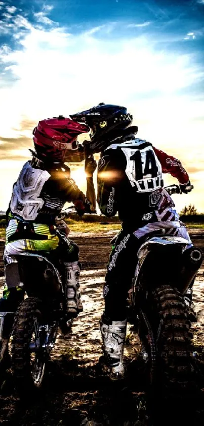 Motocross riders at sunset with dramatic sky.