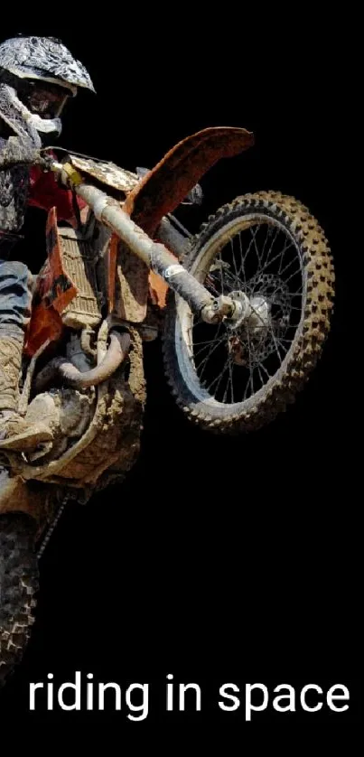 Motocross biker performing a stunt on a black background wallpaper.