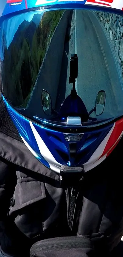 Motorcycle helmet reflection with scenic road and mountains.