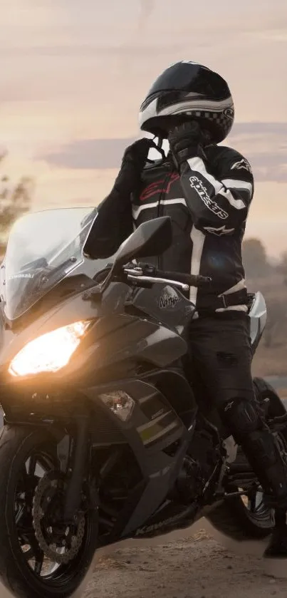 Motorcycle rider in gear at dusk with headlight on.