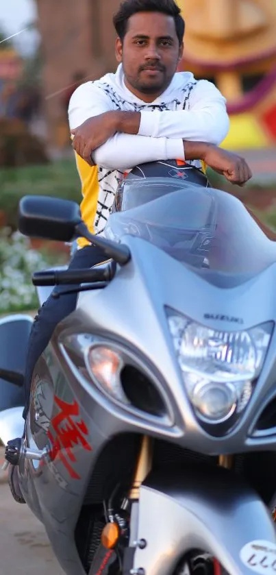 Man posing with sleek motorcycle in vibrant setting.